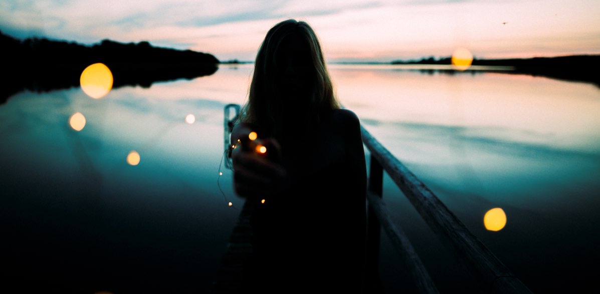 Woman by a lake, at dusk