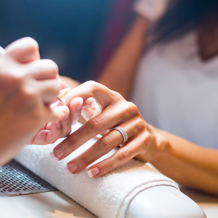 A woman getting her nails done while wearing a Montluc diamond ring